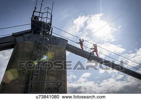 Bridge workers walking on cable of suspension bridge under bright sunlight. The Humber Bridge, UK was built in 1981 and at the time was the world's largest single-span suspension bridge View Large Photo Image Stock Image - Bridge workers walking on cable of suspension bridge under bright sunlight. The Humber Bridge, UK was built in 1981 and at the time was the world's largest single-span suspension bridge. Fotosearch