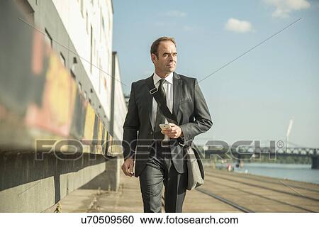 Stock Image - Businessman alongside building. Fotosearch