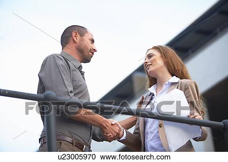 Businessman and business woman shaking hands View Large Photo Image Stock Image - Businessman and business woman shaking hands. Fotosearch