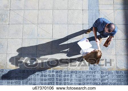 Stock Photograph - Businessman and business woman shaking hands. Fotosearch