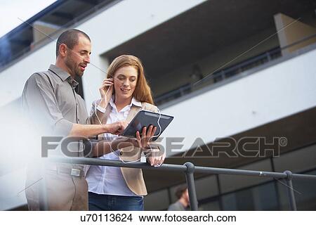 Picture - Businessman and business woman using digital tablet. Fotosearch