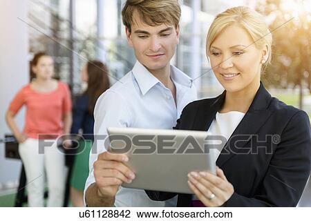 Businessman and businesswomen sharing information on digital tablet View Large Photo Image Stock Image - Businessman and businesswomen sharing information on digital tablet. Fotosearch