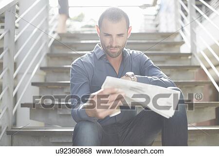 Businessman reading newspapers on staircase View Large Photo Image Stock Photo - Businessman reading newspapers on staircase. Fotosearch