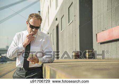 Businessman using smartphone View Large Photo Image Stock Photo - Businessman using smartphone. Fotosearch