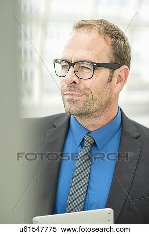 Stock Photography - Businessman wearing glasses, looking away. Fotosearch
