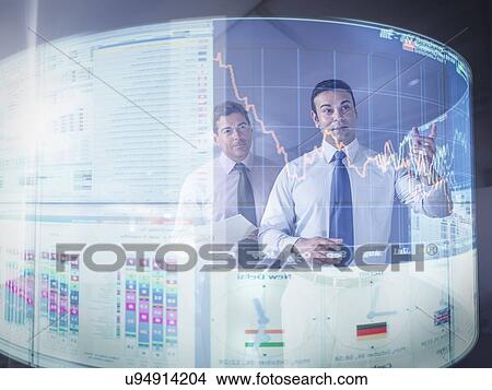Picture - Businessmen inspecting graph on interactive display. Fotosearch
