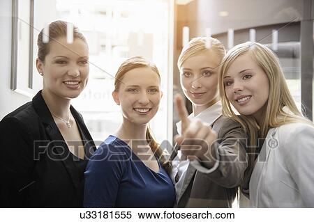 Businesswomen looking and pointing on glass View Large Photo Image Stock Photography - Businesswomen looking and pointing on glass. Fotosearch