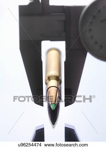 Picture - Calipers measuring bullet for forensic investigation. Fotosearch