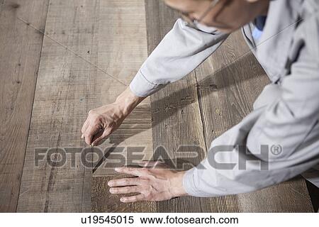 Stock Photography - Carpenter checking quality of wood plank in factory, Jiangsu, China. Fotosearch