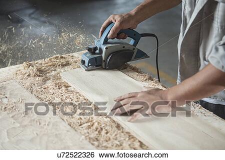 Stock Photograph - Carpenter cutting wood plank in factory, Jiangsu, China. Fotosearch