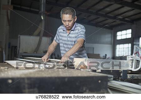 Carpenter cutting wood plank with electric saw in factory, Jiangsu, China View Large Photo Image Stock Image - Carpenter cutting wood plank with electric saw in factory, Jiangsu, China. Fotosearch