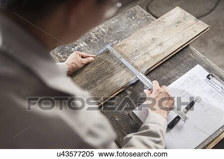 Stock Photography - Carpenter measuring wood plank with vernier caliper in factory, Jiangsu, China. Fotosearch
