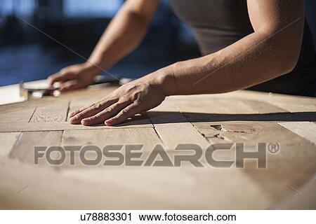 Stock Image - Carpenter piecing together wood blocks in factory, Jiangsu, China. Fotosearch