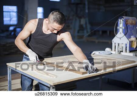 Stock Photo - Carpenter piecing together wood blocks in factory, Jiangsu, China. Fotosearch