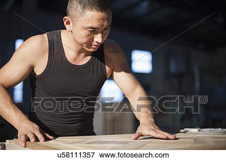 Stock Photo - Carpenter piecing together wood blocks in factory, Jiangsu, China. Fotosearch