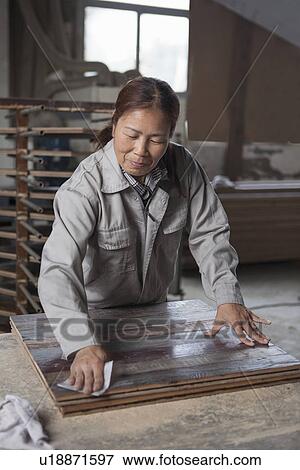 Carpenter smoothing surface of wood plank with sandpaper in factory, Jiangsu, China View Large Photo Image Stock Photo - Carpenter smoothing surface of wood plank with sandpaper in factory, Jiangsu, China. Fotosearch
