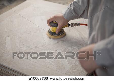 Stock Photograph - Carpenter smoothing surface of wood plank in factory, Jiangsu, China. Fotosearch
