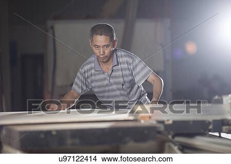 Picture - Carpenter working on wood plank in factory, Jiangsu, China. Fotosearch