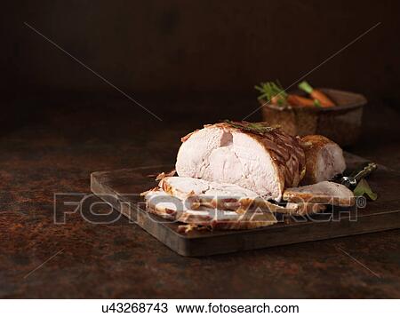Stock Image - Christmas dinner. Boneless turkey with dry cured bacon lattice with carrots. Fotosearch