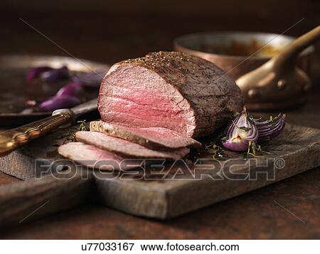Christmas dinner. Chateaubriand steak cooked with a thick cut from the tenderloin filet, rare medium served with roasted onions, pepper and herbs View Large Photo Image Stock Photo - Christmas dinner. Chateaubriand steak cooked with a thick cut from the tenderloin filet, rare medium served with roasted onions, pepper and herbs. Fotosearch