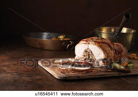 Stock Image - Christmas dinner. Oakham chicken with pork, bramley apple & cranberry stuffing. Carrots, courgettes, chopped herbs and rosemary bacon. Fotosearch