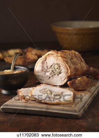 Stock Image - Christmas dinner. Roasted pork loin with pork and apple stuffing and roast potatoes. Fotosearch