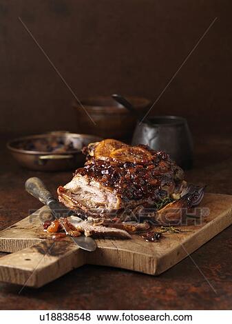 Stock Photo - Christmas dinner. Slow roasted spiced apricot & cranberry lamb with roasted red onions. Fotosearch
