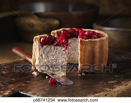 Christmas snack of cranberry topped pork pie on chopping board View Large Photo Image Picture - Christmas snack of cranberry topped pork pie on chopping board. Fotosearch