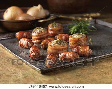 Stock Photo - Christmas snack of premium garnish selection. Roast stuffed bacon rolls with rosemary, onions and pigs in blankets. Fotosearch