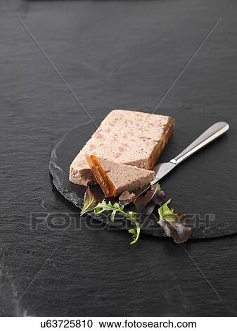Stock Image - Christmas snack with Ardennes pate and rocket mixed salad leaves on slate cutting board. Fotosearch