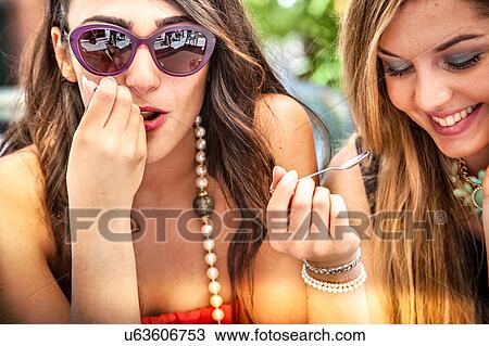 Close up of two young female friends with teaspoons at sidewalk cafe, Cagliari, Sardinia, Italy View Large Photo Image Stock Image - Close up of two young female friends with teaspoons at sidewalk cafe, Cagliari, Sardinia, Italy. Fotosearch
