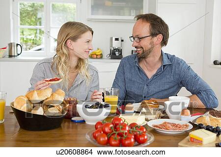 Couple eating at kitchen table View Large Photo Image Picture - Couple eating at kitchen table. Fotosearch