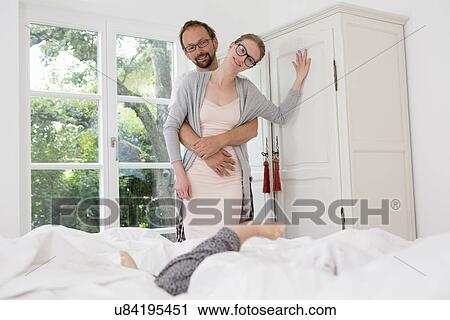 Couple in bedroom, woman leaning against wardrobe View Large Photo Image Stock Image - Couple in bedroom, woman leaning against wardrobe. Fotosearch