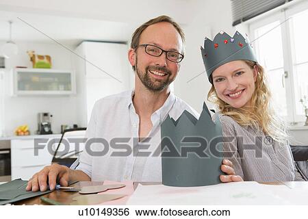 Stock Photograph - Couple making paper crowns. Fotosearch