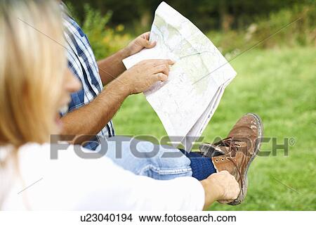Couple putting on walking shoes, map reading and preparing for walk View Large Photo Image Picture - Couple putting on walking shoes, map reading and preparing for walk. Fotosearch