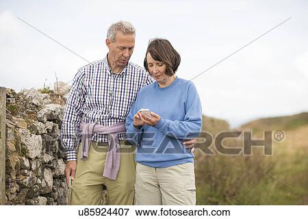 Stock Photo - Couple texting, Coast Path near Marloes, Pembrokeshire Coast National Park, Wales, UK. Fotosearch