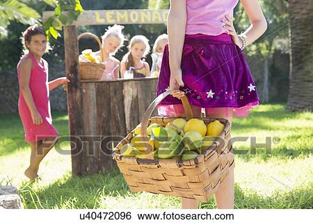 Cropped shot of girl carrying basket of lemons in front of lemonade stand View Large Photo Image Stock Photograph - Cropped shot of girl carrying basket of lemons in front of lemonade stand. Fotosearch