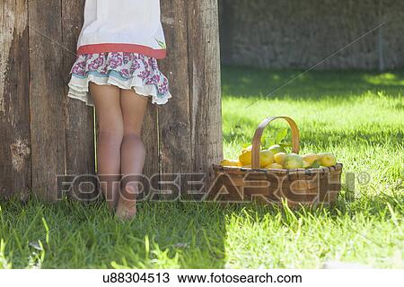 Stock Image - Cropped shot of girl leaning against lemonade stand. Fotosearch