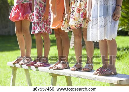 Cropped shot of the legs of five girls standing on garden bench View Large Photo Image Stock Photograph - Cropped shot of the legs of five girls standing on garden bench. Fotosearch