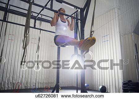 Crossfitter doing chin ups in gym View Large Photo Image Stock Image - Crossfitter doing chin ups in gym. Fotosearch