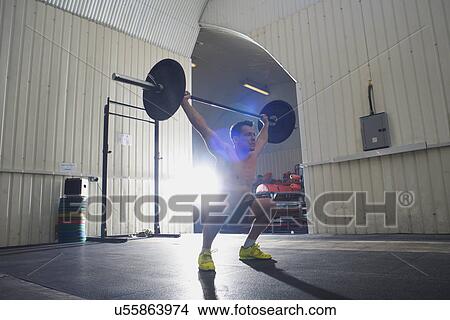 Crossfitter lifting barbell in gym View Large Photo Image Picture - Crossfitter lifting barbell in gym. Fotosearch