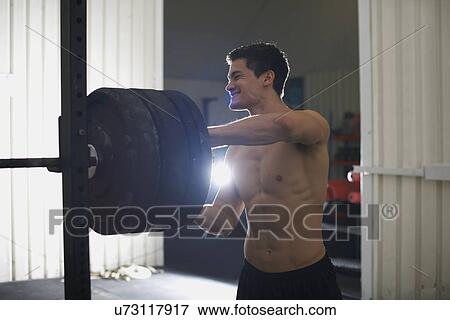 Crossfitter with barbells in gym View Large Photo Image Stock Photo - Crossfitter with barbells in gym. Fotosearch