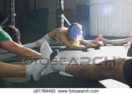 Crossfitters stretching on floor View Large Photo Image Stock Photography - Crossfitters stretching on floor. Fotosearch