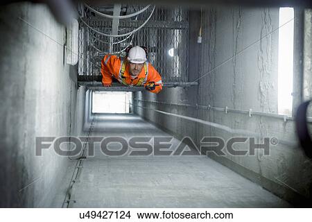 Picture -  Engineer inspecting tower shaft in suspension bridge. The Humber Bridge, UK was built in 1981 and at the time was the world's largest single-span suspension bridge. Fotosearch