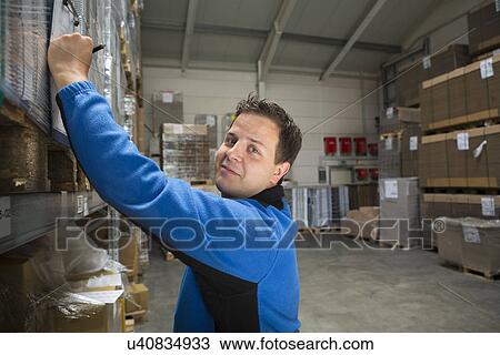 Stock Image - Factory worker checking pallets. Fotosearch