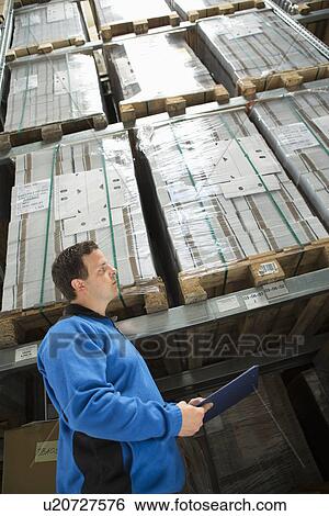 Factory worker checking pallets View Large Photo Image Stock Photograph - Factory worker checking pallets. Fotosearch