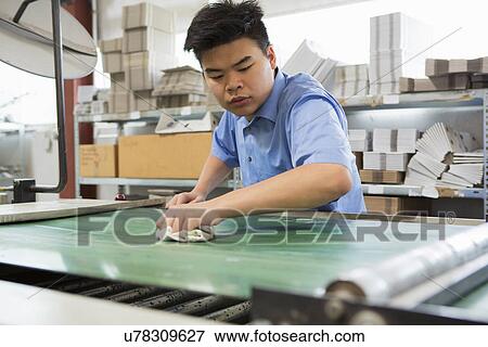 Factory worker cleaning machinery View Large Photo Image Stock Photo - Factory worker cleaning machinery. Fotosearch