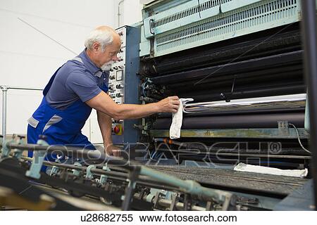 Factory worker cleaning machinery View Large Photo Image Stock Photography - Factory worker cleaning machinery. Fotosearch