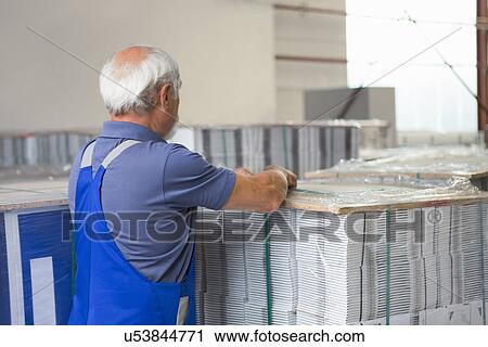 Factory worker moving and stacking cardboard View Large Photo Image Stock Image - Factory worker moving and stacking cardboard. Fotosearch