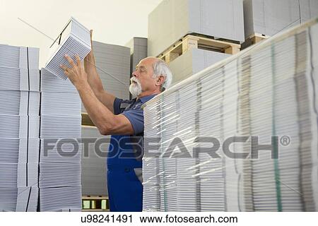 Factory worker moving and stacking cardboard View Large Photo Image Stock Image - Factory worker moving and stacking cardboard. Fotosearch